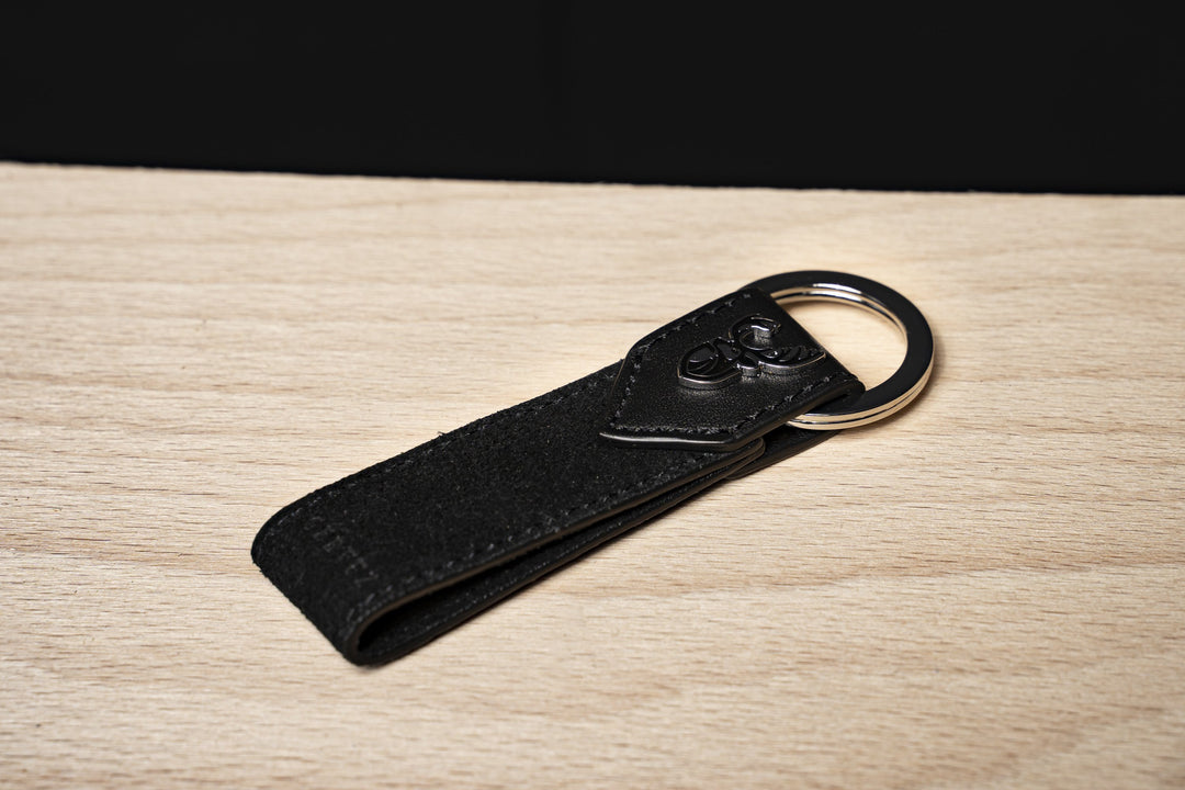 Leder Schlüsselanhänger Cervuz schwarz auf Holztisch#farbe_rabenschwarz
